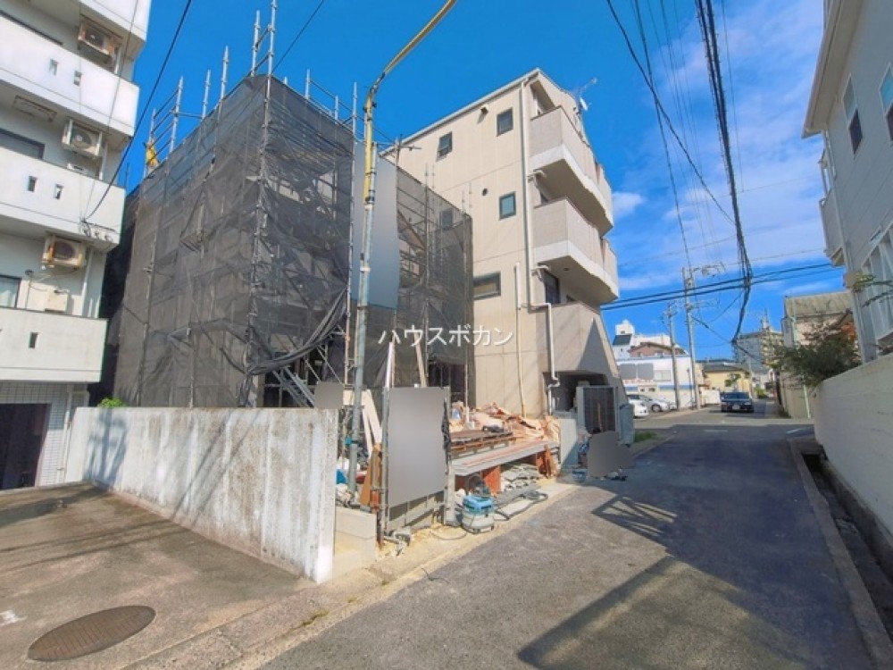 足場に覆われた建築中の外観です。