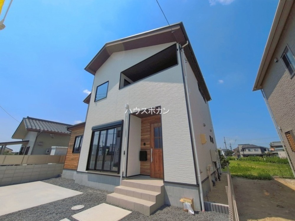 白い外壁と木目調玄関が映えるおしゃれな外観！