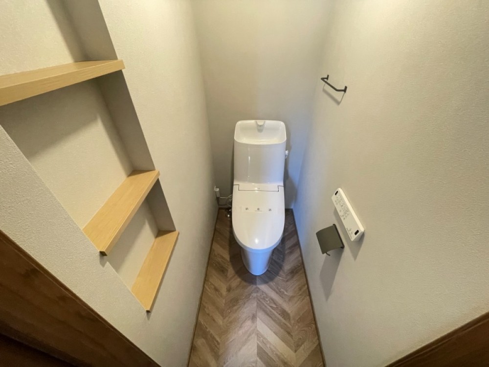 収納棚付きの清潔感あるトイレです。